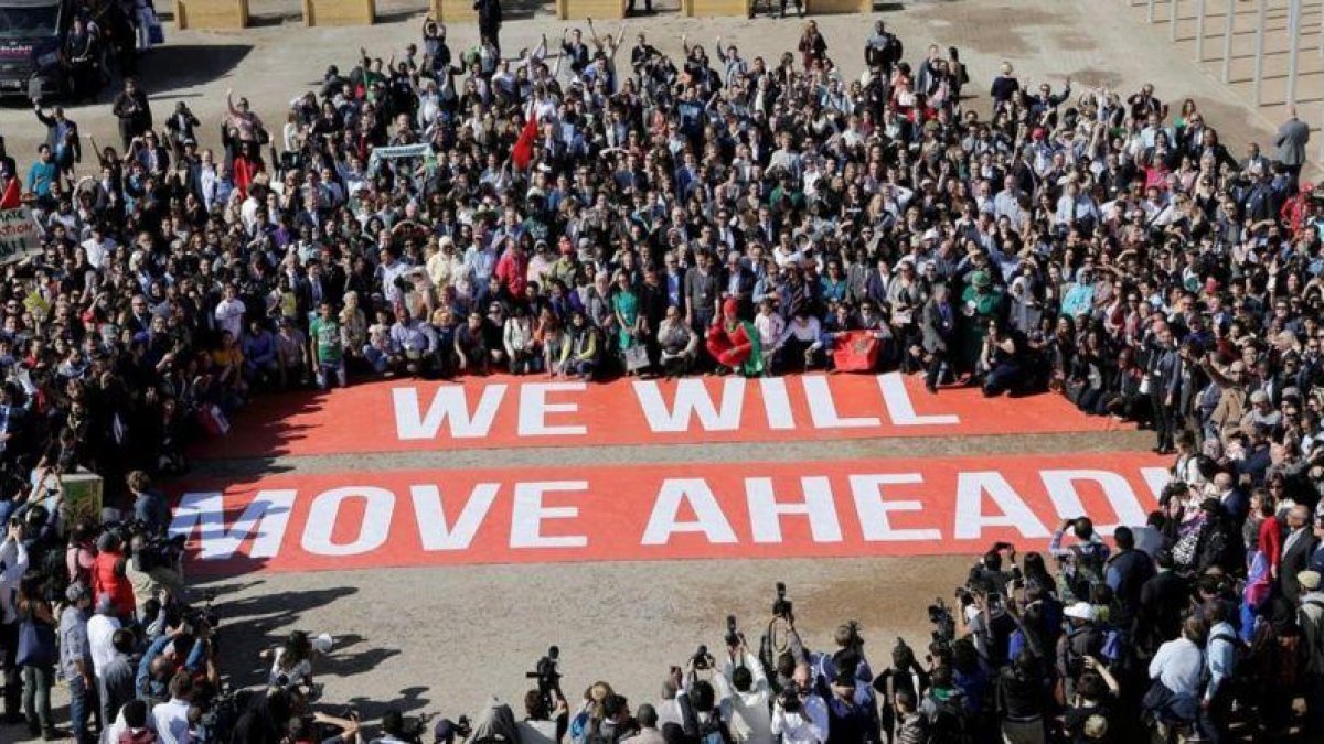 Pancarta llamando a no desfallecer desplegada durante la jornada final de la conferencia del clima de Marrakech. El lema equivale en español a "Avanzaremos" o "Saldremos adelante".