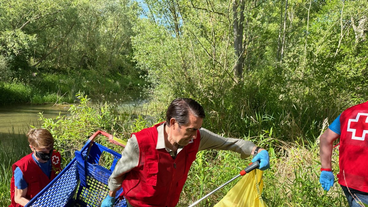Suárez Quiñones ayuda a retirar un carrito de la compra del río Torío. DL