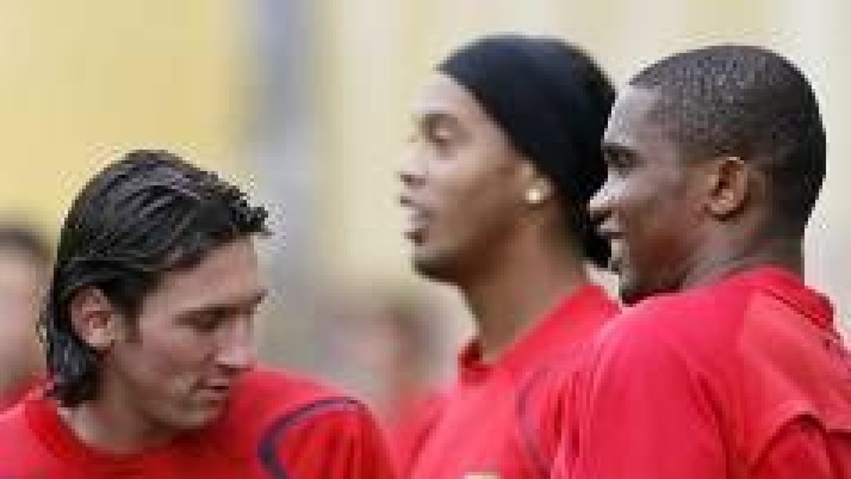El camerunés Samuel Eto'o conversa con Ronaldinho y Messi durante el entrenamiento de ayer