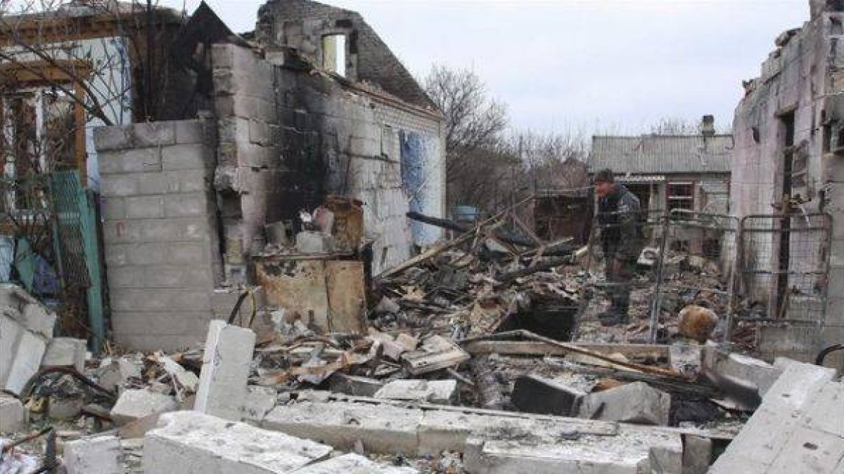 Un rebelde prorruso camina entre edificios destruidos en una calle de Donetsk, este martes.