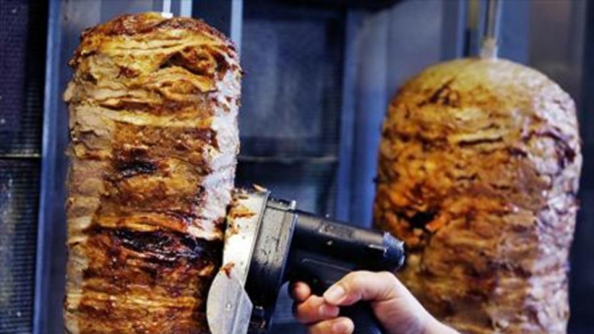 Un hombre corta carne de kebab en un establecimiento de Fráncfort.