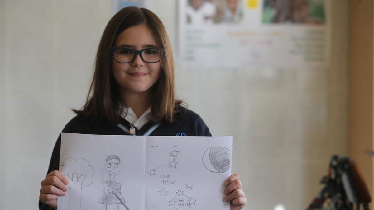 Irene Calderón posa con una copia de su dibujo en el aula del colegio Inmaculada de Ponferrada. LUIS DE LA MATA