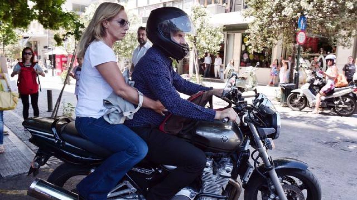 El ya exministro de Finanzas griego, Yanis Varoufakis, y su mujer, Danae Stratou, encima de una moto a la puerta de su casa, en Atenas.