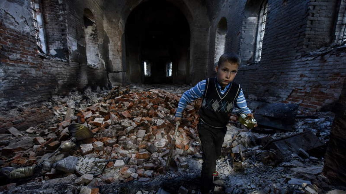 Un niño camina entre las ruinas de una iglesia de Chirnighiv bombardeada por los rusos. OLEG PETRASYUK