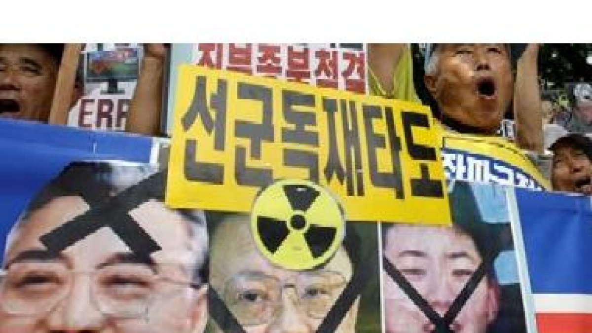 Unos surcoreanos muestran pancartas con los rostros de los líderes de Corea del Norte tachados