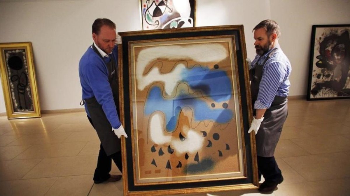 Dos operarios portugueses trasladan en febrero del 2014 una obra de Miró para la subasta que finalmente no se llevó a cabo.
