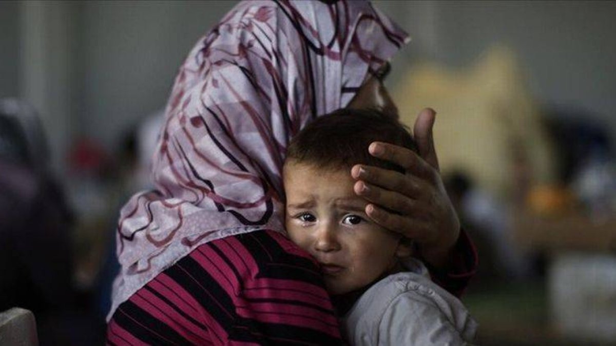 Una mujer siria consuela a su hijo, once días después de abandonar su casa tras un bombardeo del régimen en Marea, el pasado septiembre.