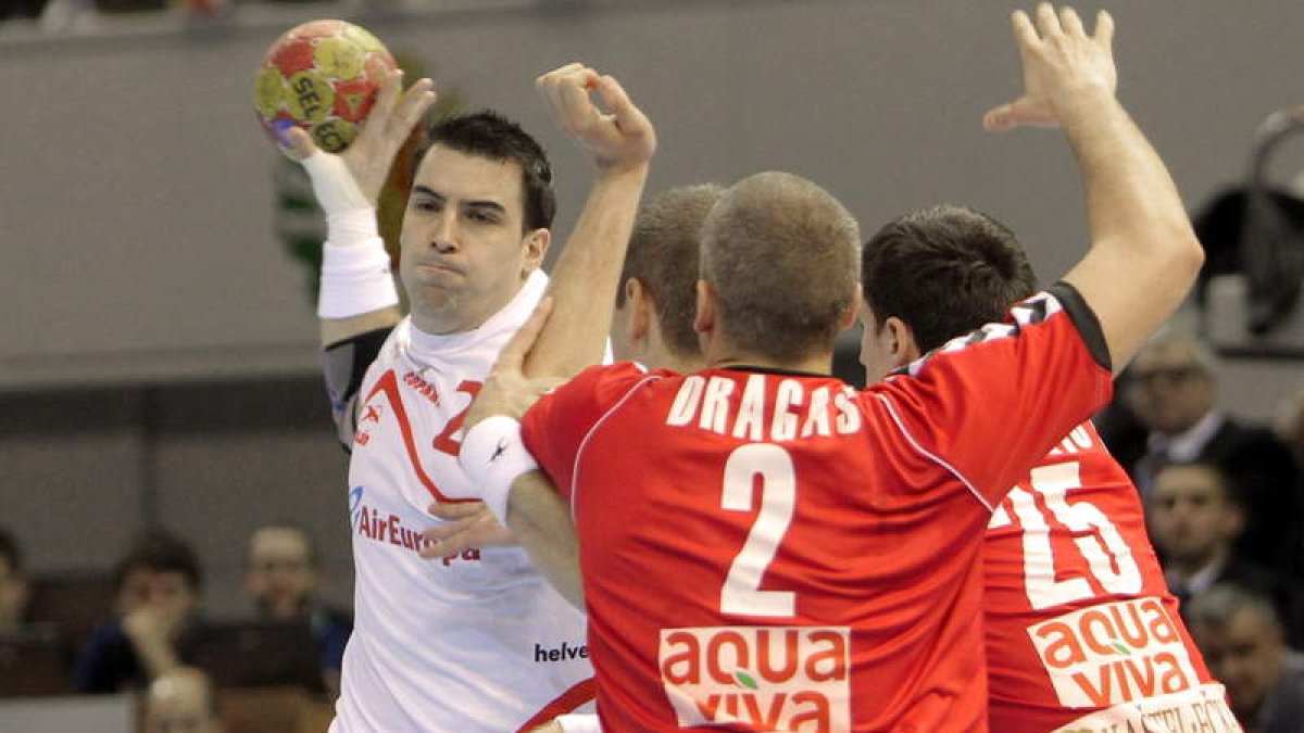 El lateral del Ademar, Carlos Ruesga, intenta lanzar ante la oposición de los jugadores de Serbia Milos Dragas y Nemanja Zelenovic, durante el encuentro de ayer en Zaragoza.