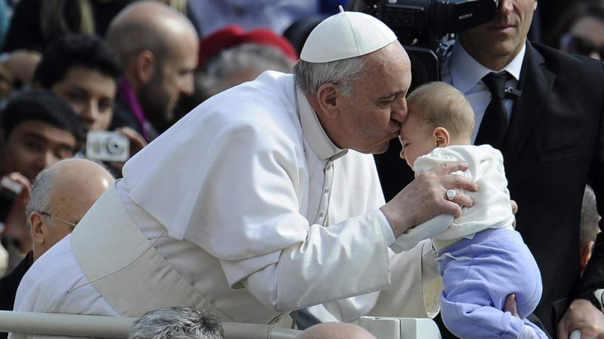El Pontífice besa cariñosamente a un bebé en su primera audiencia pública.