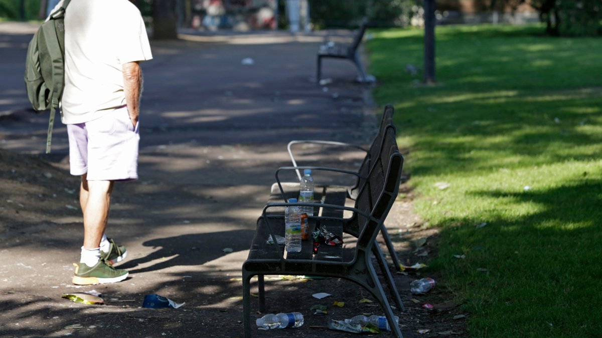 Fotografía de archivo de un hombre junto a basura en las calles de León. FERNANDO OTERO