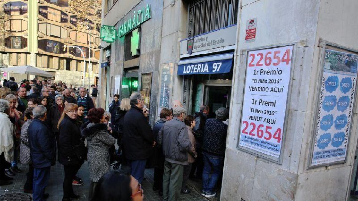 Largas colas para comprar Lotería de El Niño en la Administración nº 97 de Barcelona, en la plaza de Urquinaona.