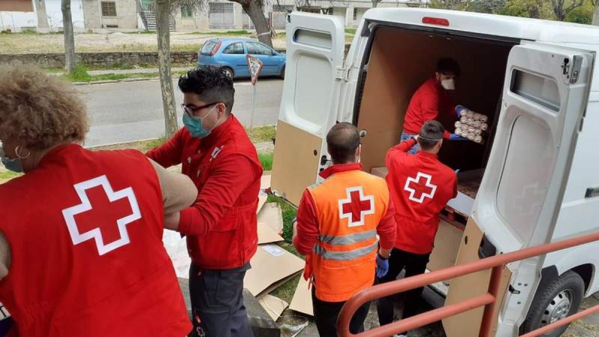 Personas voluntarias de Cruz Roja reparten alimentos durante la pandemia. DL