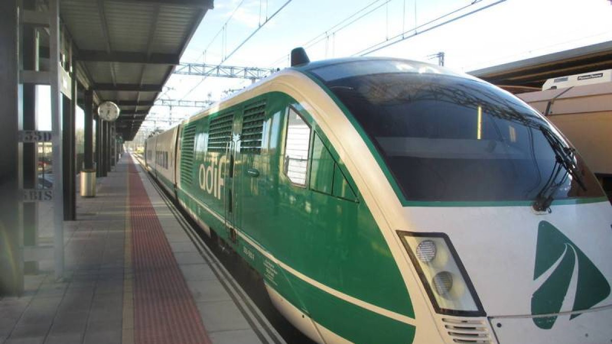 El ‘tren verde’, ayer al salir de Palencia. En pequeño, el mismo tren ya en León y trabajos de pulido del suelo de la estación ante la inminente visita de la ministra