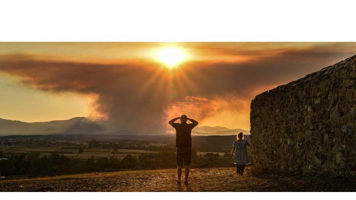 Varios vecinos observan el avance del fuego del campo de tiro del Teleno. DL