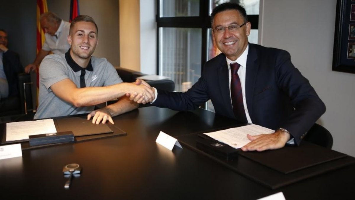 Gerard Deulofeu estrecha la mano de Josep Maria Bartomeu tras firmar su contrato.