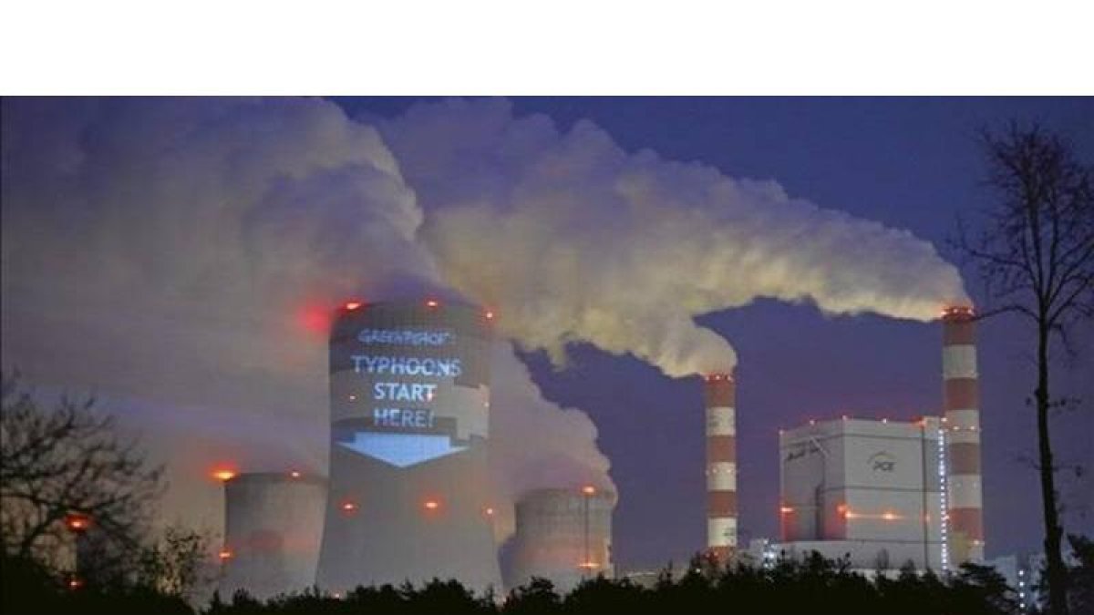 Acción de protesta de Greenpeace en una torre de refrigeración de la central térmica polaca de Belchatow, la mayor planta europea dedicada a la producción de electricidad a partir de carbón. 'Los tifones empiezan aquí', subraya el cartel.