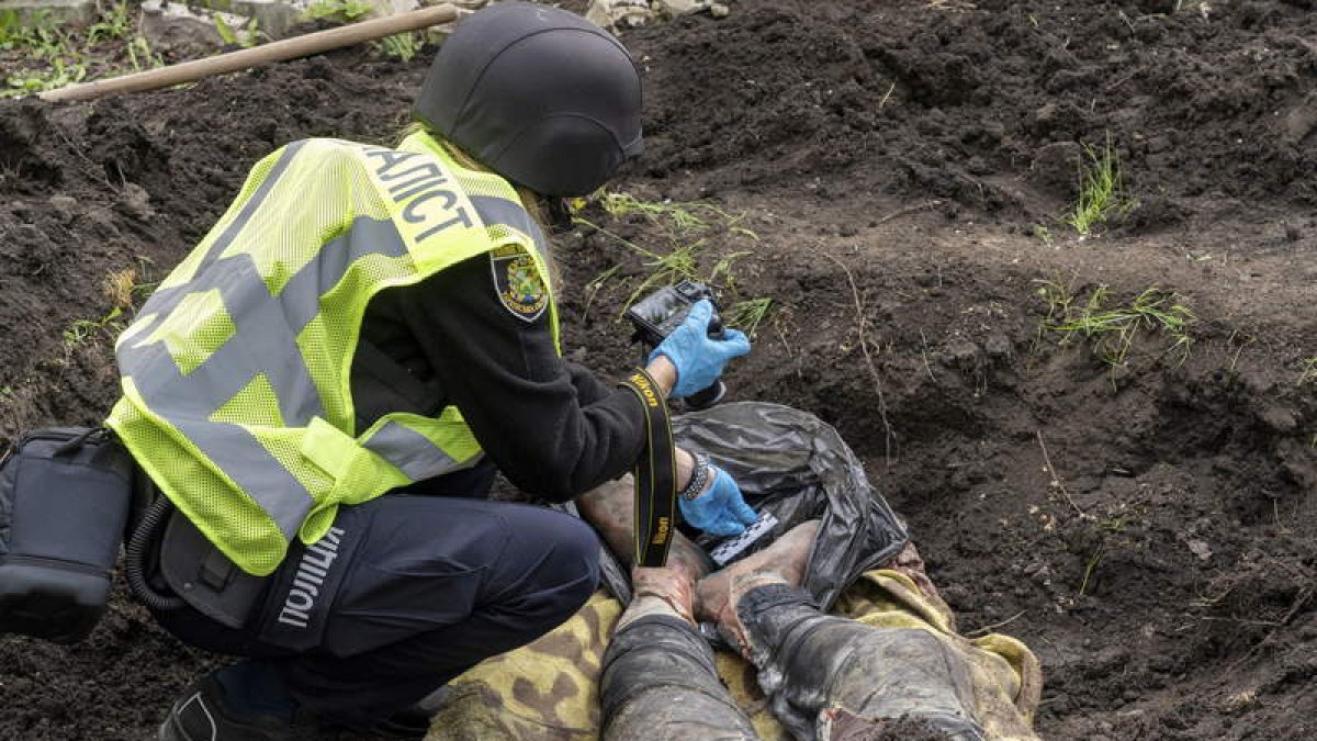 Imagen de un soldado ucraniano fotografiando el cadáver de un civil en Jarkov. VASILIY ZHLOBSKY