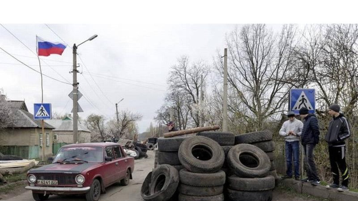 Un coche pasa junto a un control de manifestantes prorrusos en Donetsk (Ucrania).
