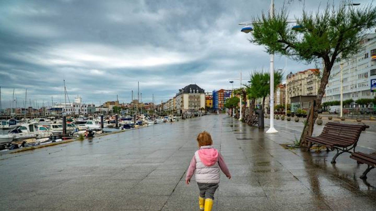 Una niña pasea por Santander este viernes, a pesar de la lluvia esta mañana. ROMÁN G. AGUILERA