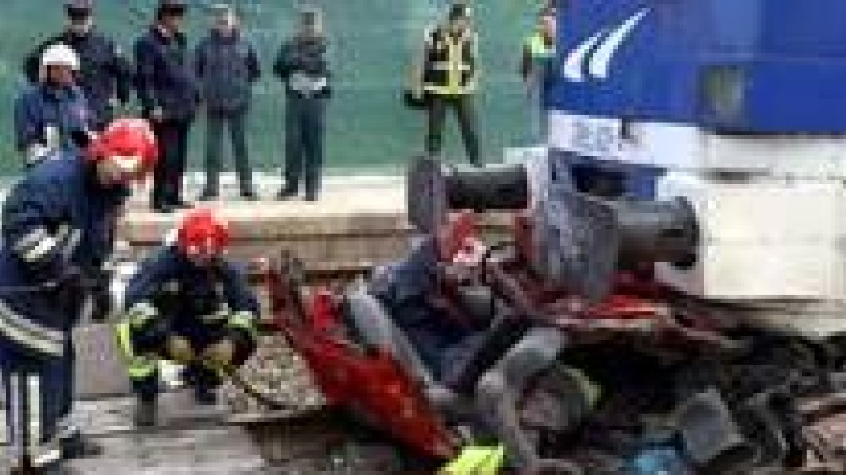 Los bomberos de Albacete examinan los restos del vehículo destrozado por el tren ayer en Hellín