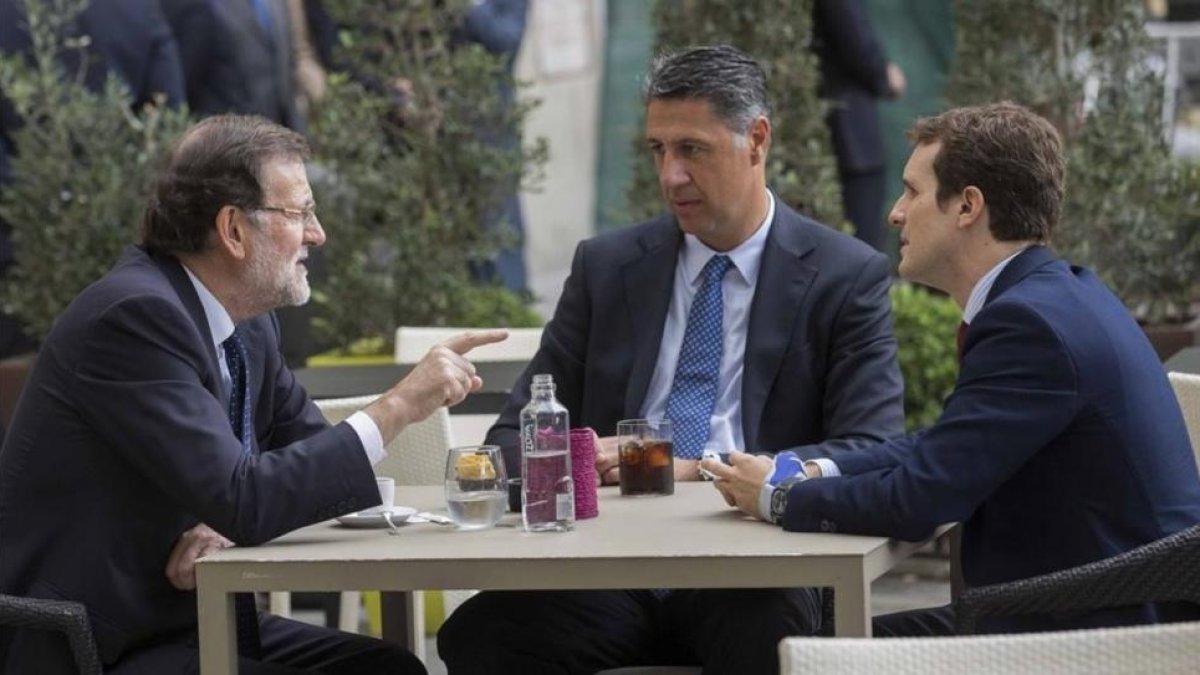 El presidente del Gobierno, Mariano Rajoy, con el vicesecretario de comunicación del PP, Pablo Casado, y el líder del PPC, Xavier García Albiol.  / TAREK