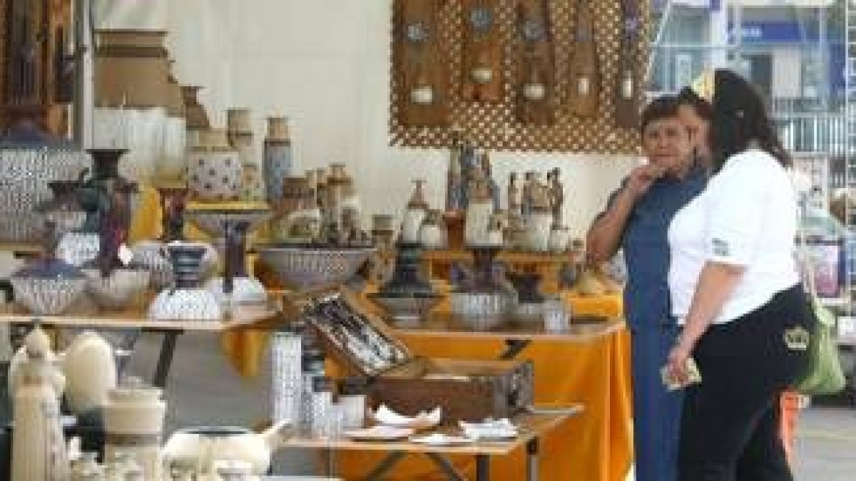 Dos visitantes observan uno de los sesenta expositores con los que abrió ayer la feria de cerámica