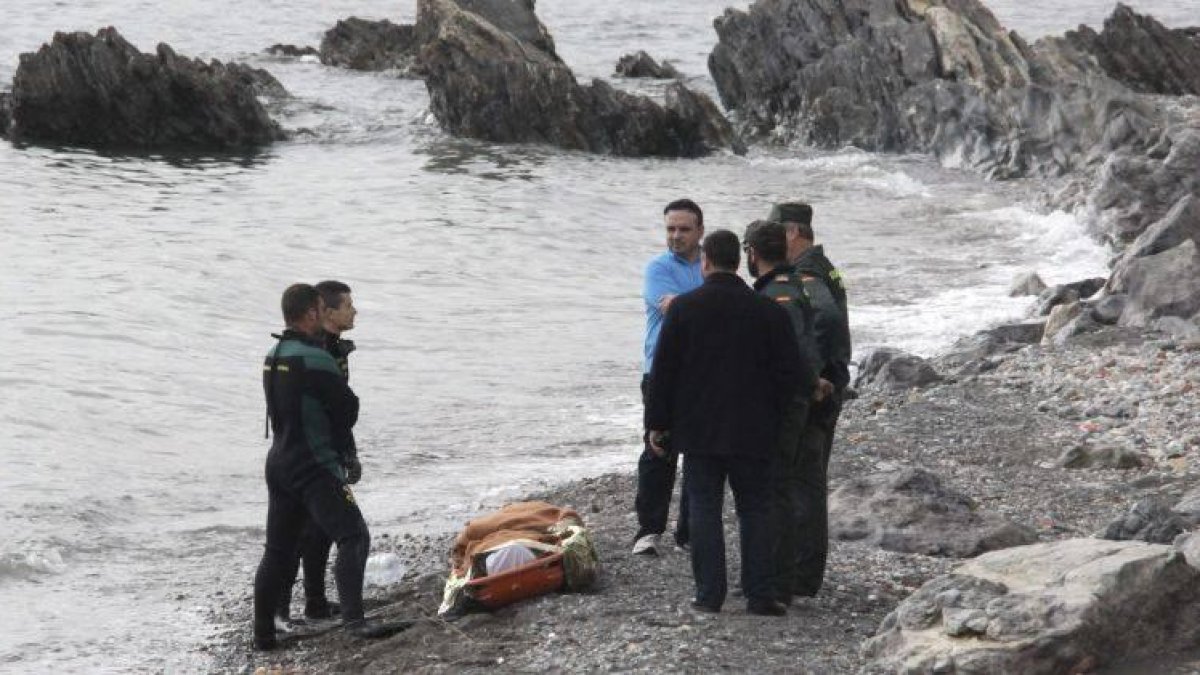 Miembros de la Guardia Civil, junto a uno de los dos cadáveres hallados el sábado en la playa de la Ribera, en Ceuta.