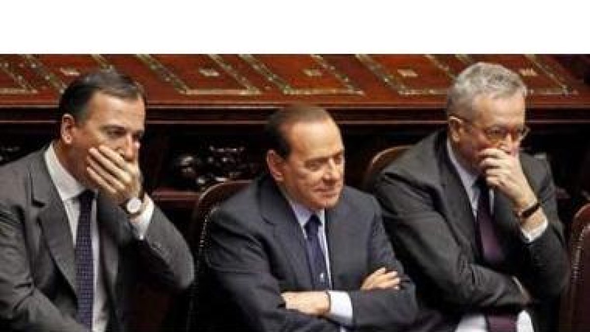 Berlusconi,  flanqueado por su ministro de Exteriores, Frattini y el titular de Economía, Tremonti.