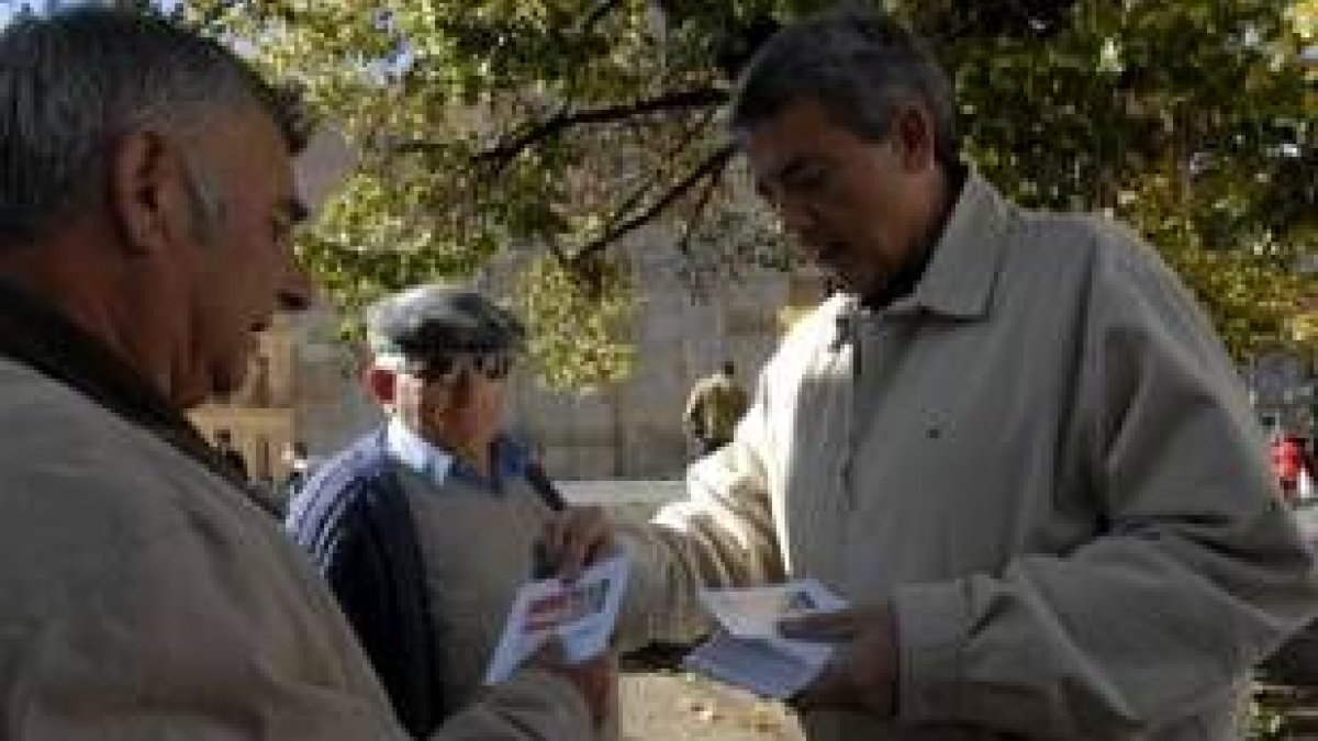 Martínez entrega uno de los trípticos a dos hombres en San Marcelo