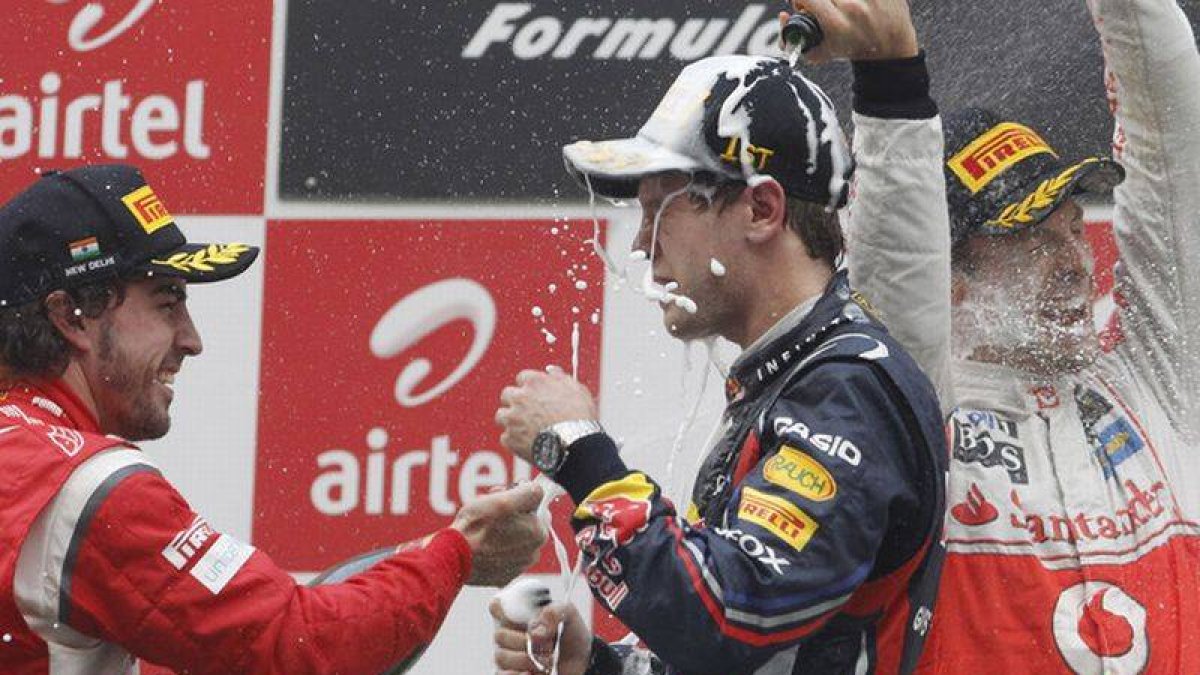 Vettel y Alonso se tiran champán en lo alto del podio.