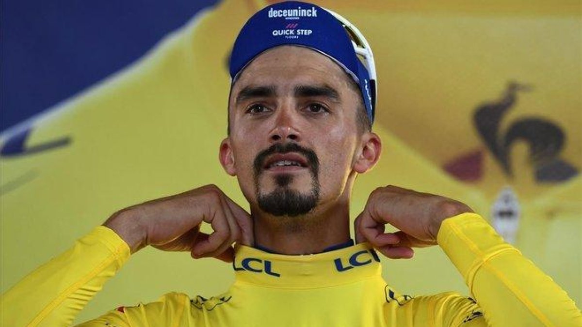 Julian Alaphilippe se ajusta el jersey amarillo en el podio de Toulouse.