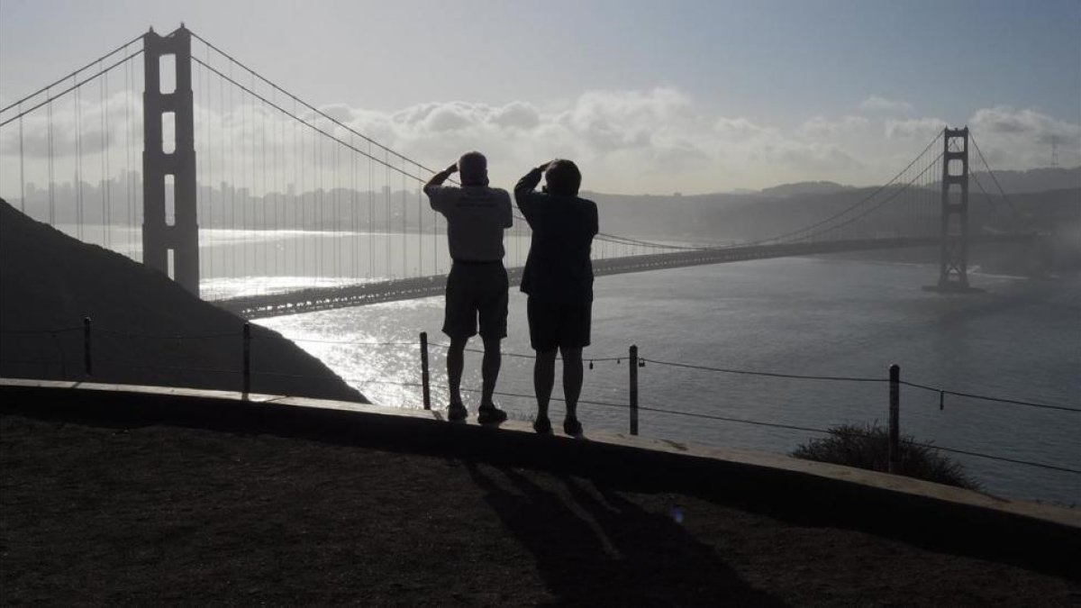 Dos turistas toman fotos del Golden Gate Bridge, en San Francisco, en una imagen de archivo