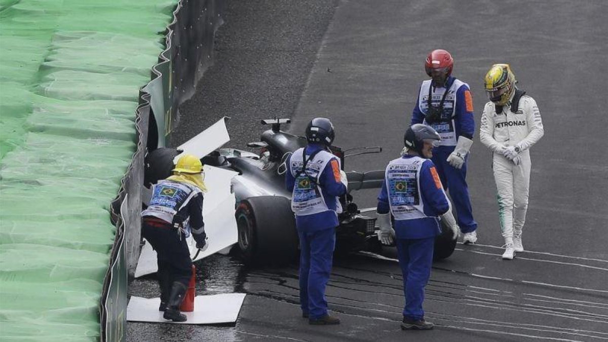 Lewis Hamilton, al lado de su Mercedes siniestrado.