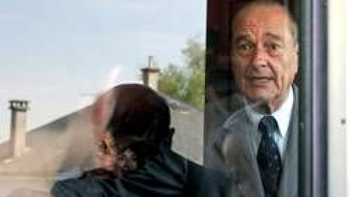 Chirac mira por la ventana del colegio electoral donde depositó su voto