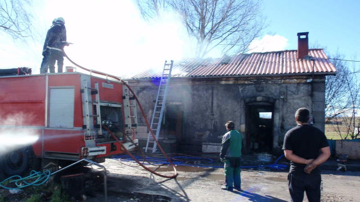Los bomberos voluntarios, sofocando un incendio en los pabellones del Oeste en febrero de 2014. A.V.