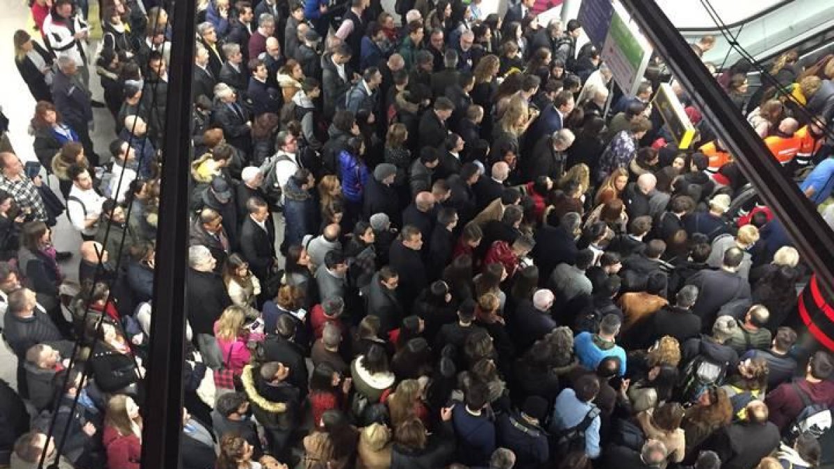 Miles de personas se agolpan a las puertas de un vagón del Metro de Madrid para desplazarse hasta Ifema