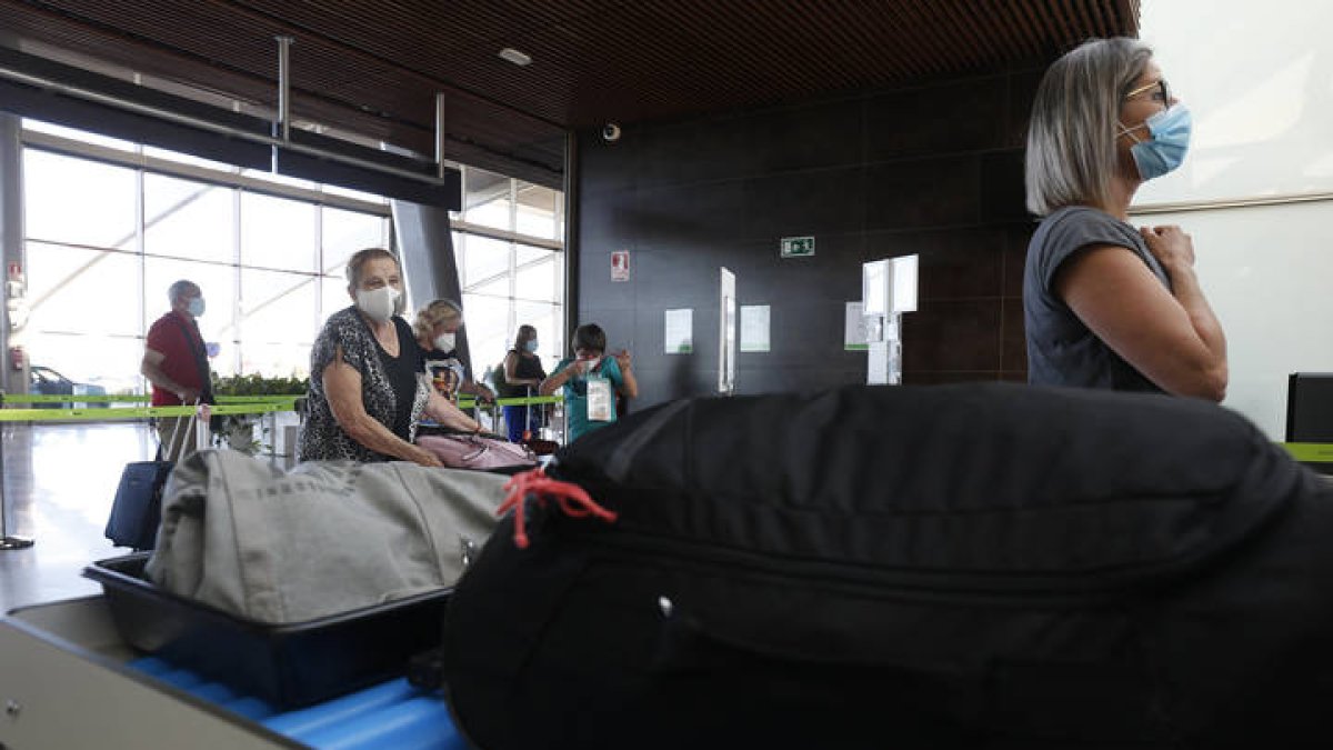 Varias personas dejan sus equipajes en el control de aeropuerto de León. FERNANDO OTERO