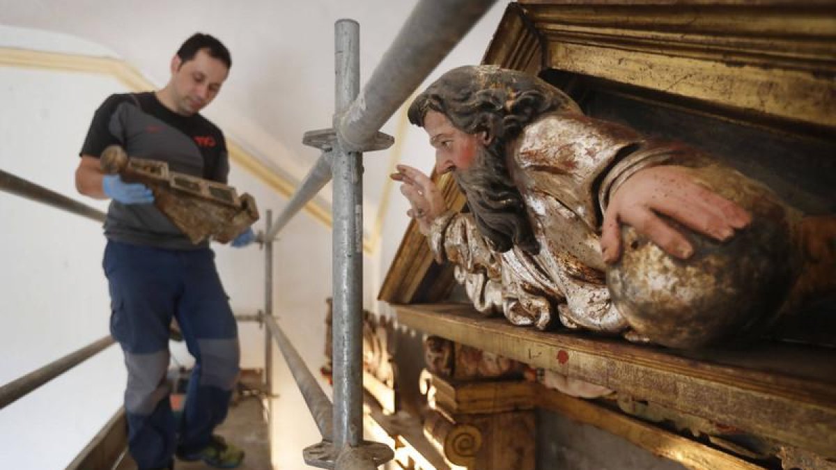 El restaurador Manuel Martínez trabajando en el retablo de la iglesia de Villanueva de las Manzanas.