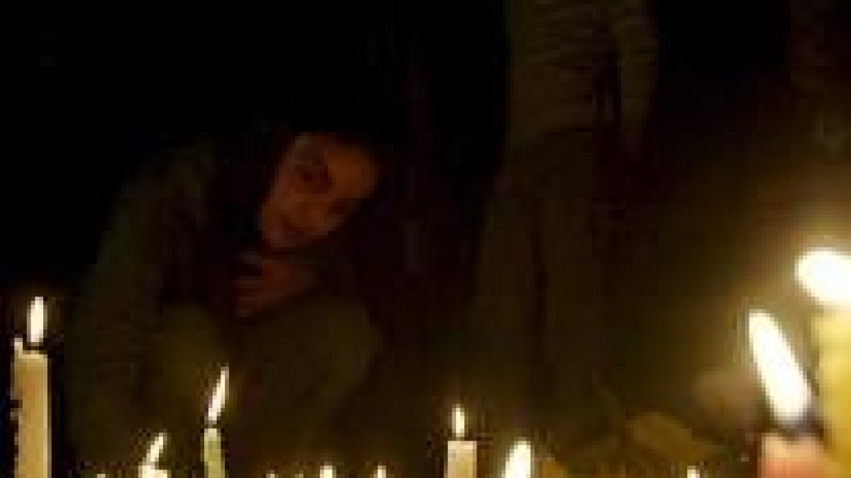 Una niña enciende una vela durante una vigilia en memoria de las víctimas de los atentados