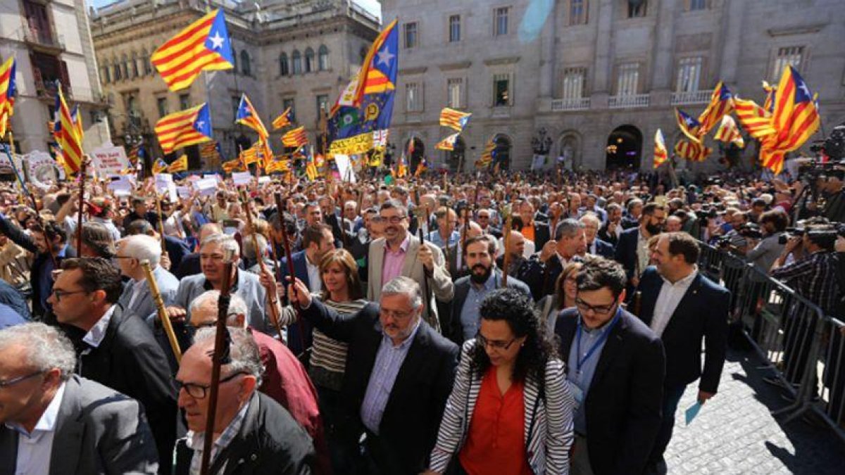 Los alcaldes y resto de autoridades cruzan la plaza Sant Jaume desde el ayuntamiento al Palau de la Generalitat