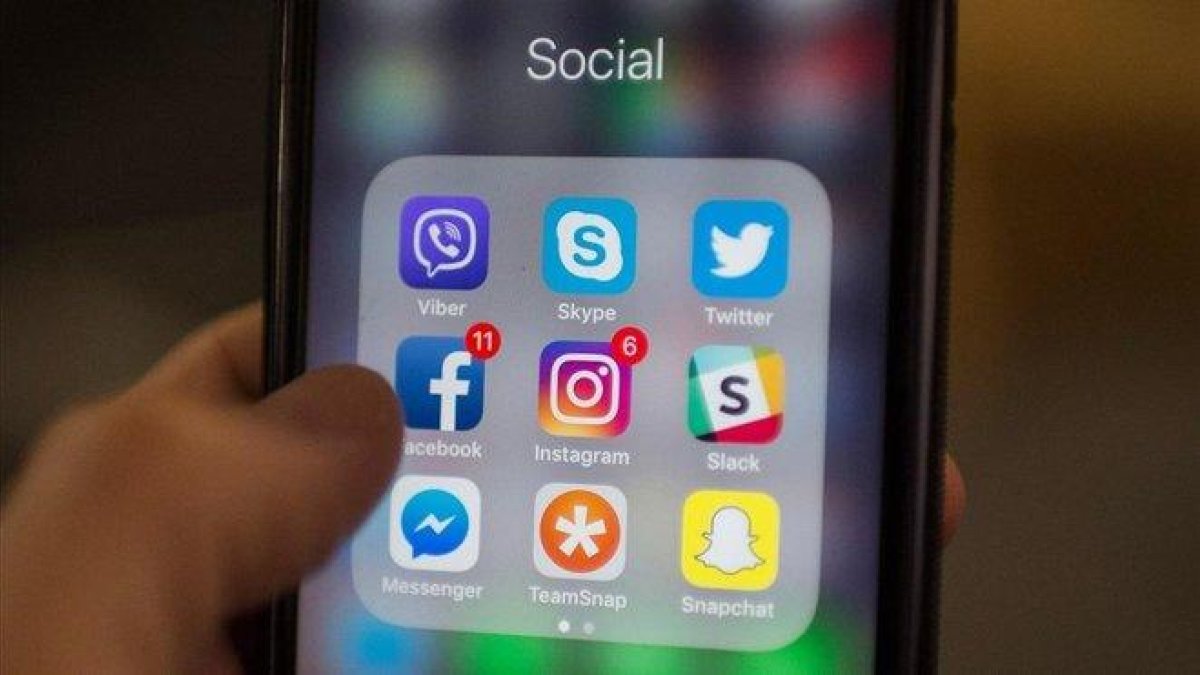 Un usuario consulta las redes sociales en su móvil.