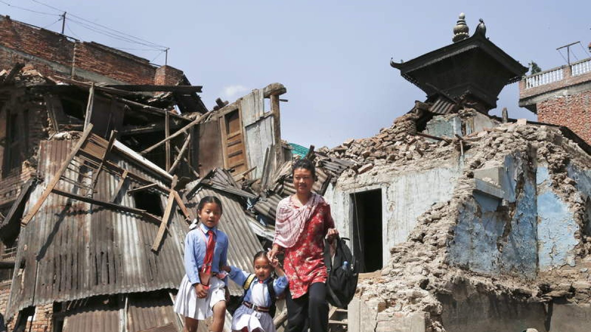 Una mujer lleva a sus hijas a la escuela en Katmandú.