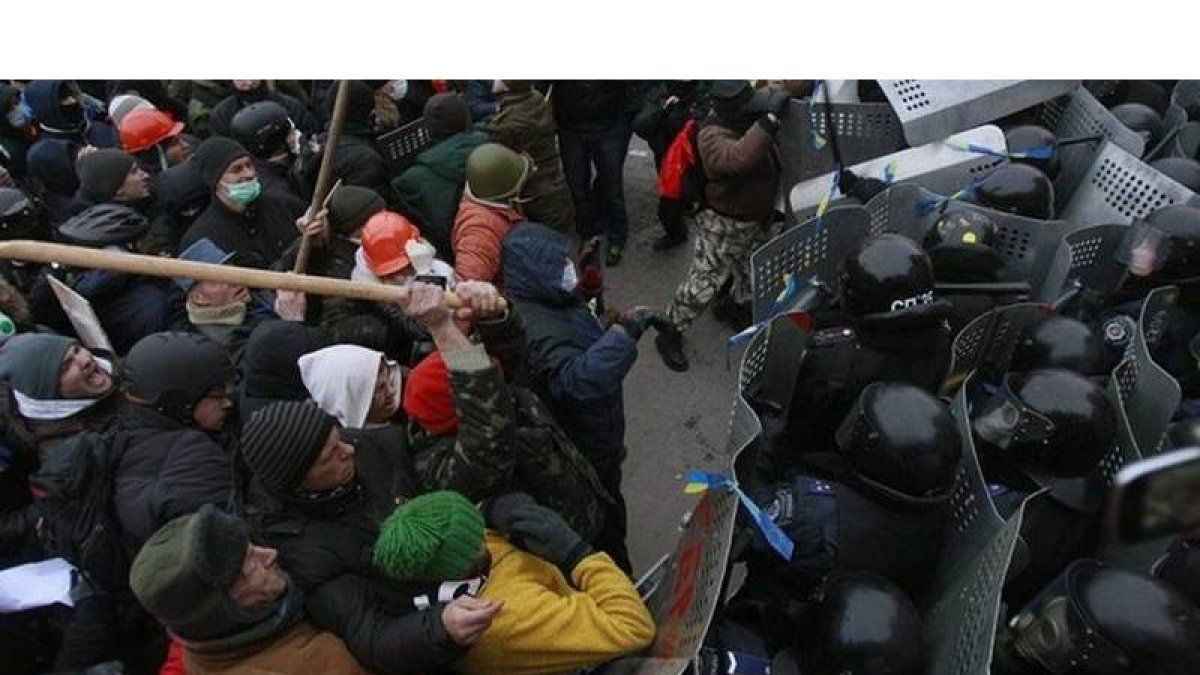 Manifestantes y policías enfrentándose junto a la sede del Gobierno ucraniano.
