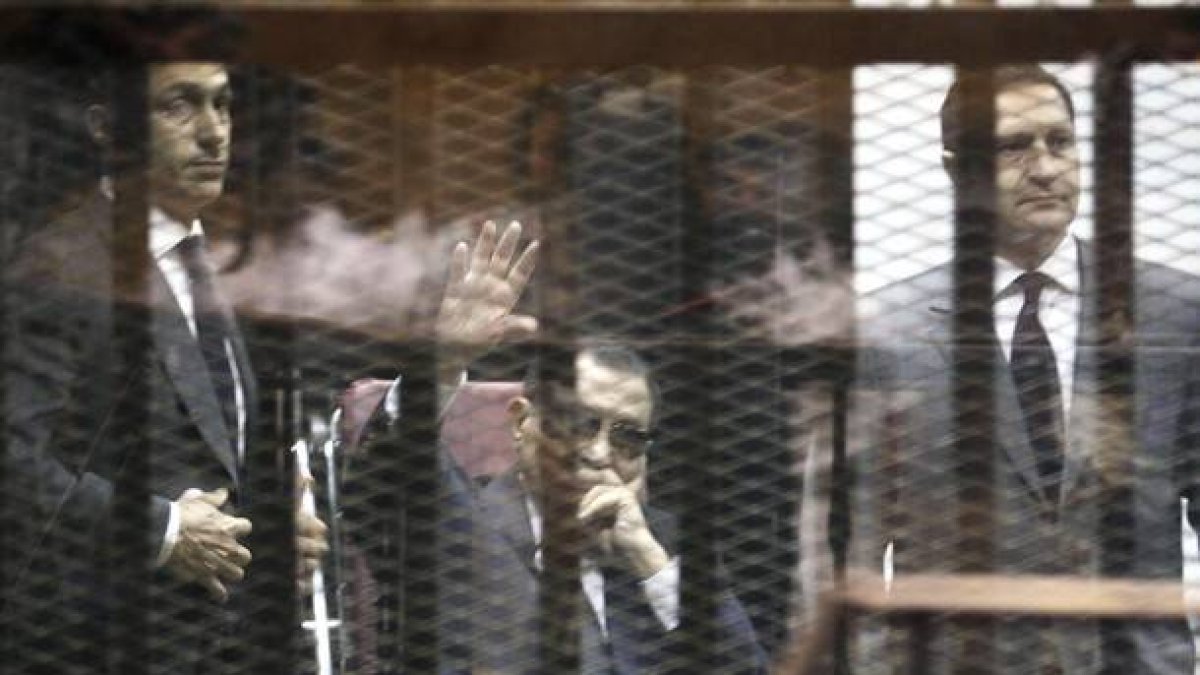 Imagen de archivo fechada el 9 de mayo de 2015 que muestra al expresidente egipcio, Hosni Mubarak (centro), flanqueado por sus hijos durante un juicio en la Academia de Policía de El Cairo (Egipto).
