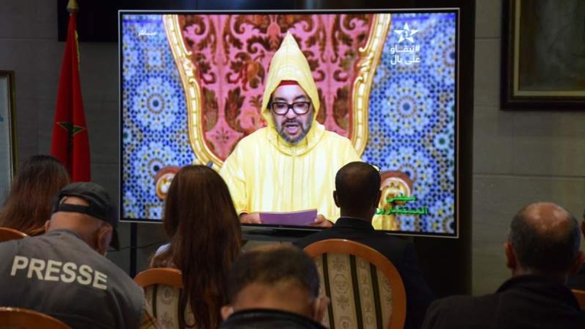Un grupo de periodistas sigue la declaración del rey de Marruecos en una de las salas del Parlamento, en Rabat. MOHAMED SIALI