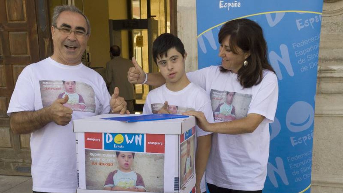 Rubén y sus padres con las cajas de firmas recogidas en su apoyo