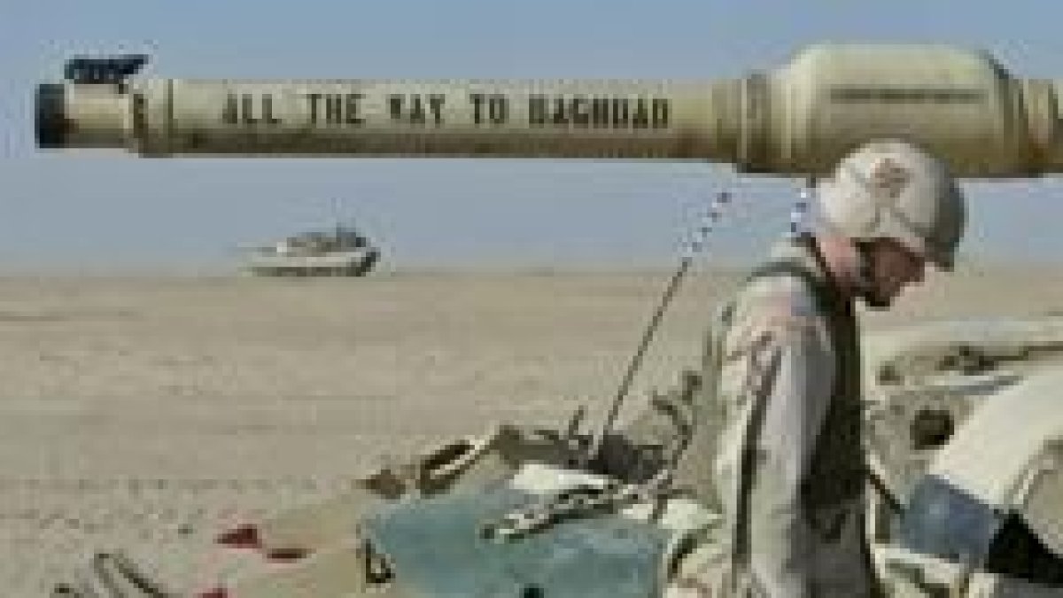Un soldado estadounidense en el desierto de Kuwait. Su tanque está preparado para llegar a Bagdad