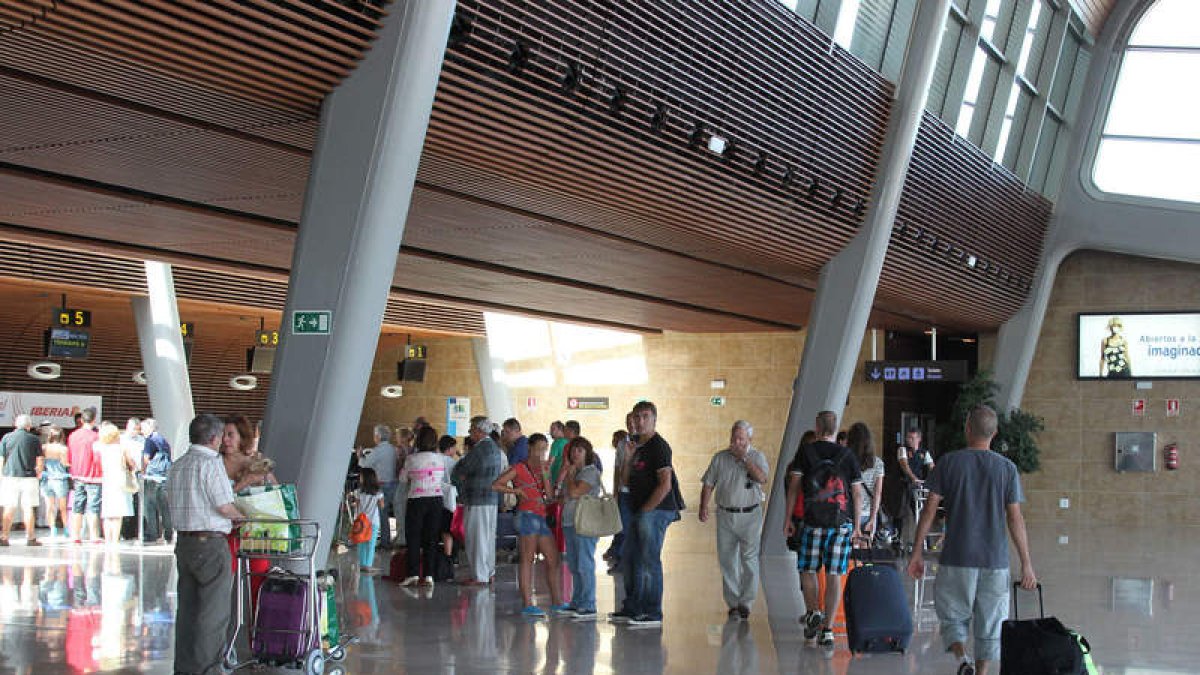 Usuarios del aeropuerto de León hacen cola en los mostradores de facturación este verano.