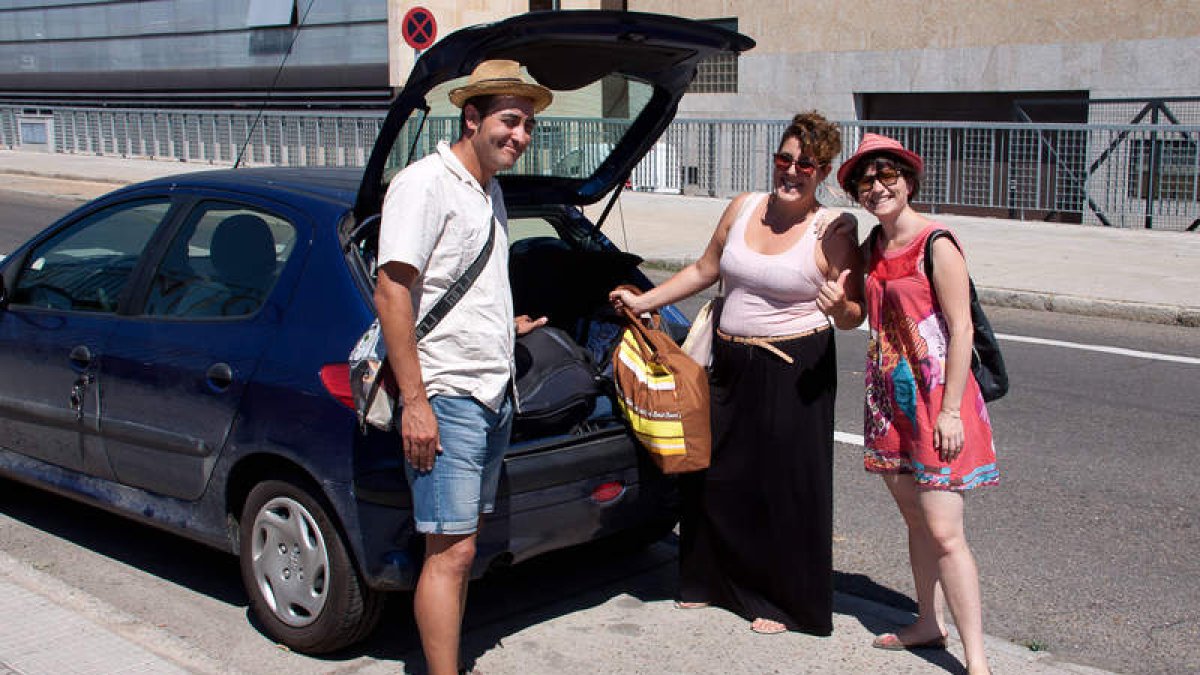 César Ochoa y Laia Terrón (con vestido rojo) descargando las maletas de Marta Astorgana a su llegada a León.