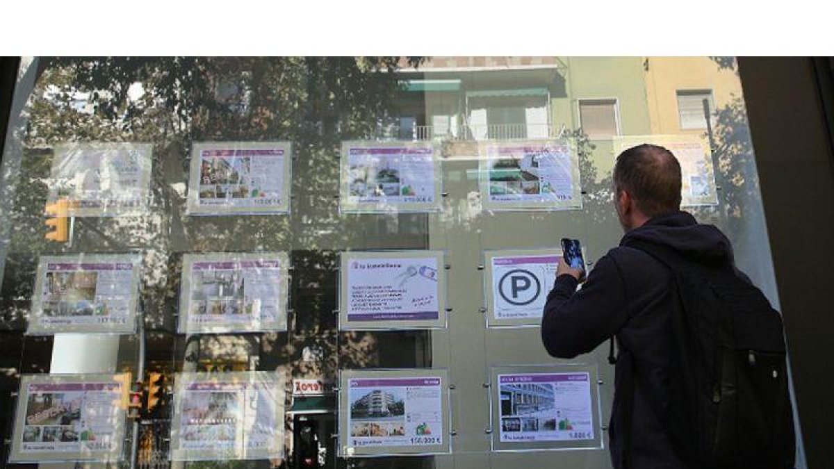 Hombre busca un piso de alquiler en una inmobiliaria de Barcelona.